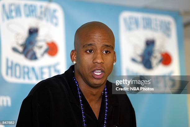 Wearing a strand of Mardi Gras beads, Courtney Alexander talks to the media in the New Orleans Arena June 26, 2002 a day after being traded from the...