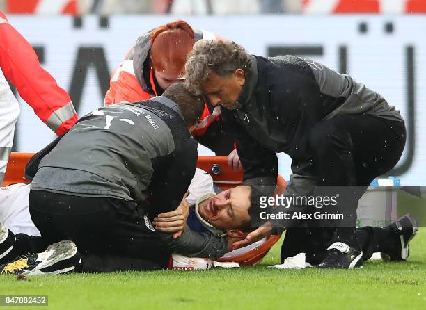 Christian Gentner of Stuttgart is being treated after a heavy foul on him by Koen Casteels of Wolfsburg during the Bundesliga match between VfB...