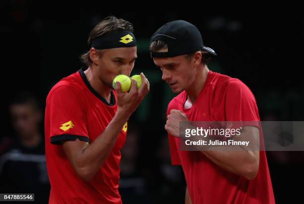Ruben Bemelmans and Arthur De Greef of Belgium talk tactics in the doubles match against John Peers and Jordan Thompson of Australia during day two...