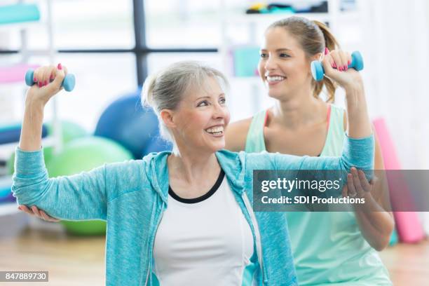 glada senior kvinna tycker styrketräning med fystränare - spotting bildbanksfoton och bilder