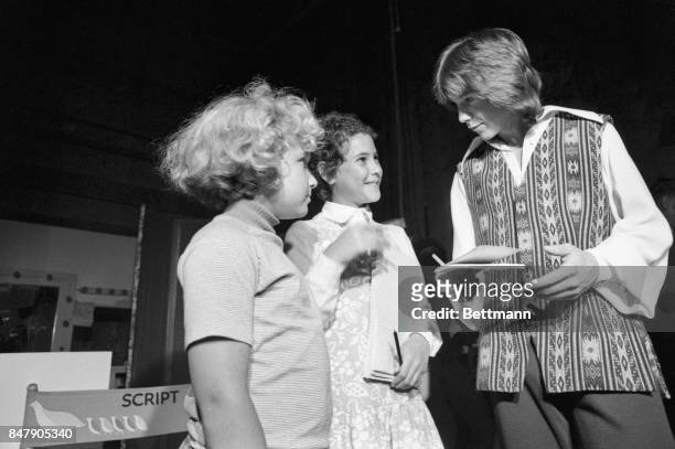 The children of Presidential adviser, Henry Kissinger, Elizabeth and David are shown as they received the autograph of singer-actor David Cassidy....