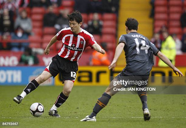 Sheffield United's Chinese player Sun Jihai comes under pressure from Hull City's Australian footballer Richard Garcia during their FA Cup fifth...