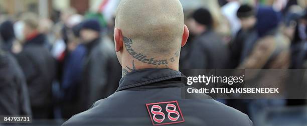 Member of the Hungarian neo-Nazi NS Front group with a tattoo of the Waffen SS unit slogan 'Loyalty is my honour' attends the 'Day of Pride' at...