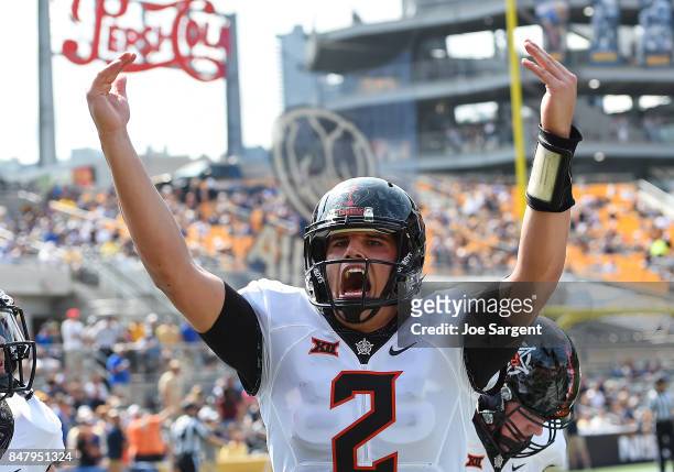 Mason Rudolph of the Oklahoma State Cowboys celebrates after a touchdown by Dillon Stoner during the first quarter against the Pittsburgh Panthers at...