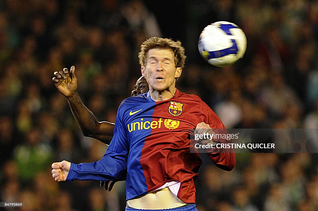 Betis's Achille Emana (L) jumps for the