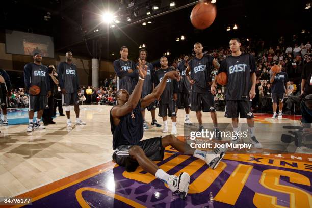 Dwight Howard of the East All-Stars attempts to break the Guiness World Record for farthest shot sitting from the floor during the East All-Stars...