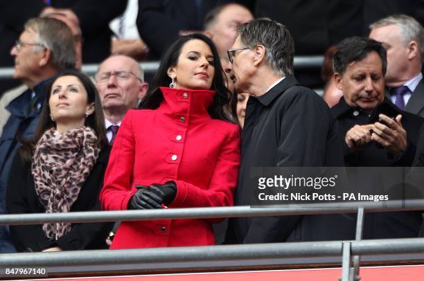 Liverpool owner John W. Henry speaks with his wife Linda Pizzuti in the stands