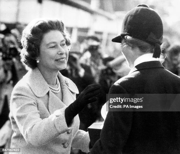 Queen Elizabeth II presenting her daughter Princess Anne with the Raleigh Trophy, the first prize and European Gold Medal at the Burghley Horse...