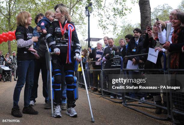 Claire Lomas who is paralysed from the chest down, wears a bionic ReWalk suit, as she kisses her daughter Maisie, after completing the London...