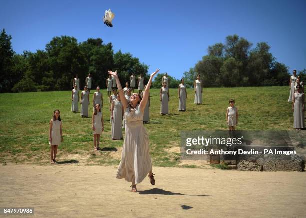 An actress dressed in the robes of the ancient Greeks releases a dove at the Temple of Hera in Olympia, Greece, where the ancient Olympic Games took...