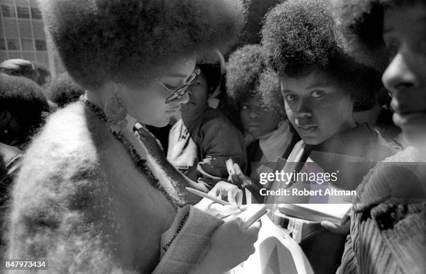 American professor of law and part of the Black Panther Party Kathleen Neal Cleaver signs autographs for a few girls during a Free Huey Rally in...