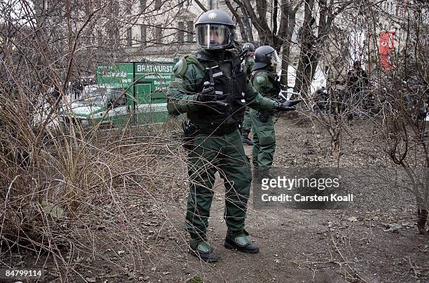 German riot police wait within the trees before going to block left-wing protestors during a rally against a far-right march on February 14, 2009 in...
