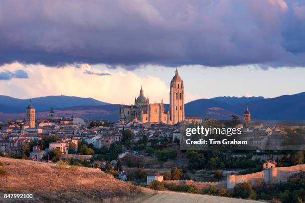 Famous view of Alcazar Castle - palace and fortress which inspired Disney castle, Cathedral and dramatic sky, Segovia, Spain.