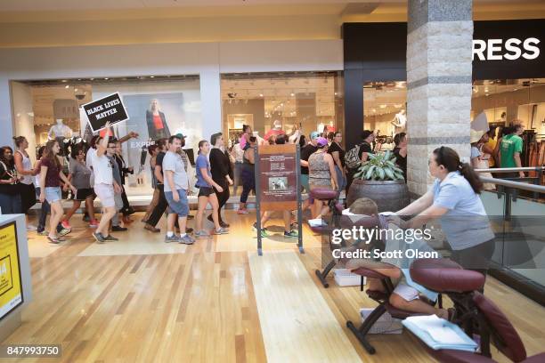 Demonstrators march through the West County Mall protesting the acquittal of former St. Louis police officer Jason Stockley on September 16, 2017 in...