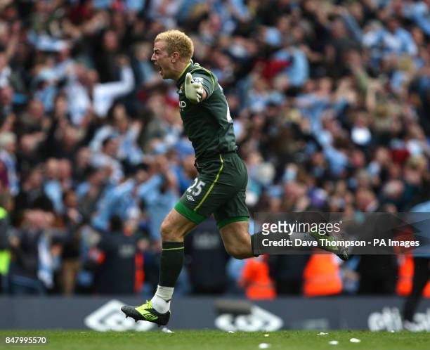 Manchester City goal keeper Joe Hart celebrates as fans invade the pitch at the final whistle during the Barclays Premier League match at the Etihad...