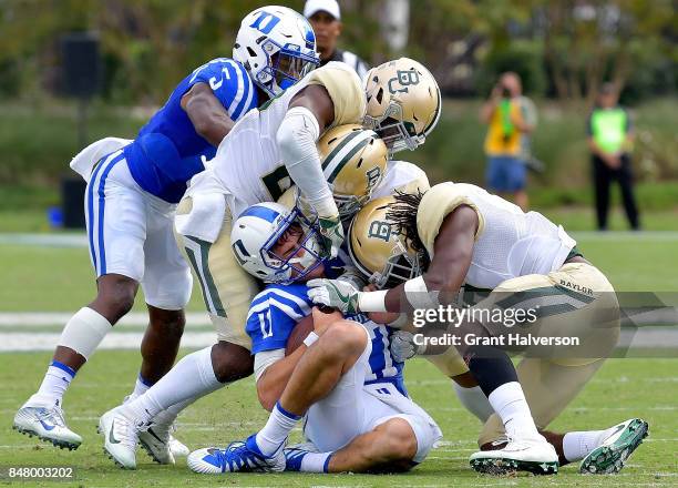 Daniel Jones of the Duke Blue Devils is tackled by the Baylor Bears defense as he slides after running for a first down during the game at Wallace...