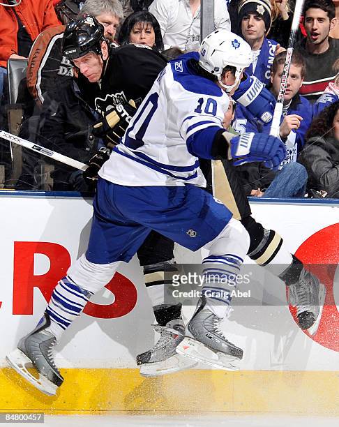 Brad May of the Toronto Maple Leafs hits Bill Thomas of the Pittsburgh Penguins during game action February 14, 2009 at the Air Canada Centre in...