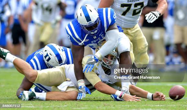 Quarterback Zach Smith of the Baylor Bears fumbles after a hit by Terrell Lucas of the Duke Blue Devils during the game at Wallace Wade Stadium on...