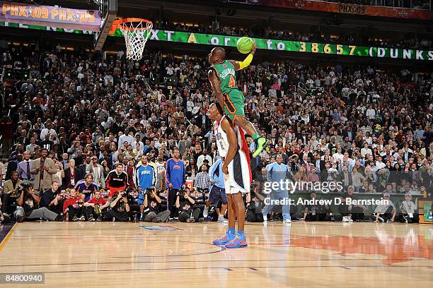 Nate Robinson of the New York Knicks dunks over Dwight Howard of the Orlando Magic in the finals of the Sprite Slam Dunk Contest on All-Star Saturday...