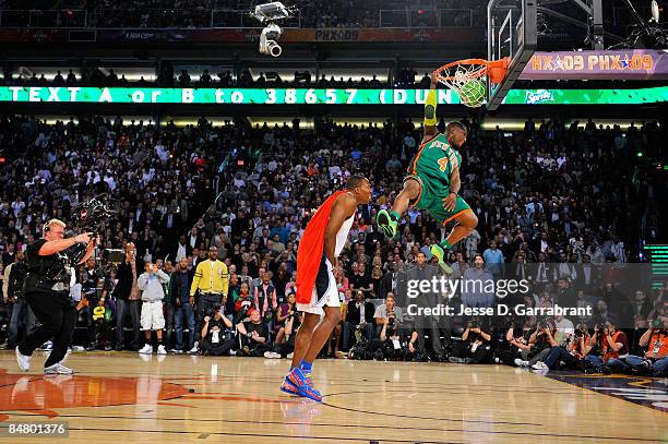 Nate Robinson of the New York Knicks jumps over Dwight Howard of the Orlando Magic on a dunk attempt during the Sprite Slam Dunk Contest on All-Star...