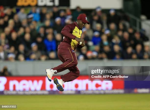 West Indies fielder Rovman Powell celebrates after catching out England batsman Jos Buttler during the T20 International cricket match between...