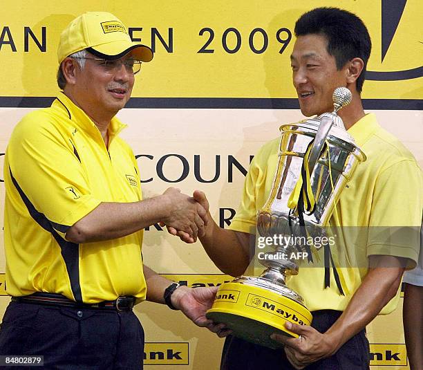 Anthony Kang of the US shakes hands with Malaysian Deputy Prime Minister Najib Razzak after receiving the winner's trophy following his victory in...