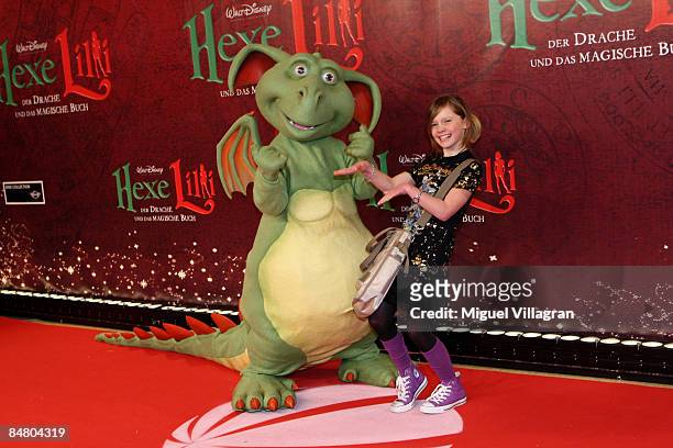 Actress Alina Freund poses for the media with Hector the dragon during the premiere of the movie 'Lilli The Witch - The Dragon And The Magical Book'...