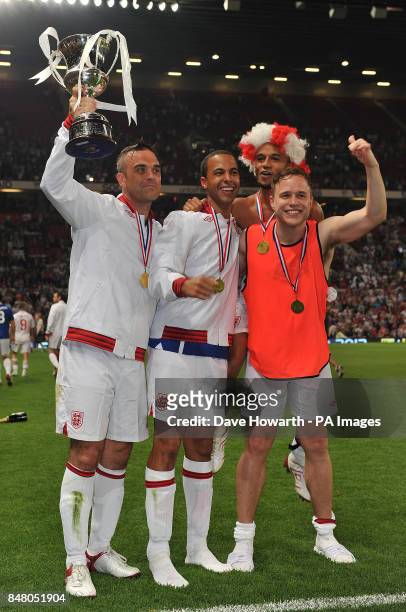 Robbie Williams, Marvin Humes Aston Merrygold and Olly Murs celebrate after England's victory in the match at Old Trafford for Soccer Aid.