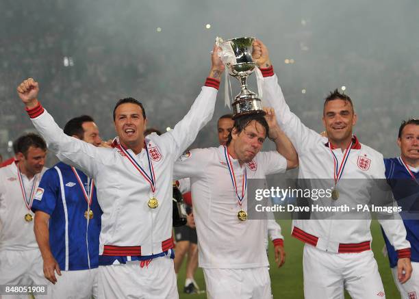 Paddy McGuiness, John Bishop and Robbie Williams celebrate after England's victory in the match at Old Trafford for Soccer Aid.