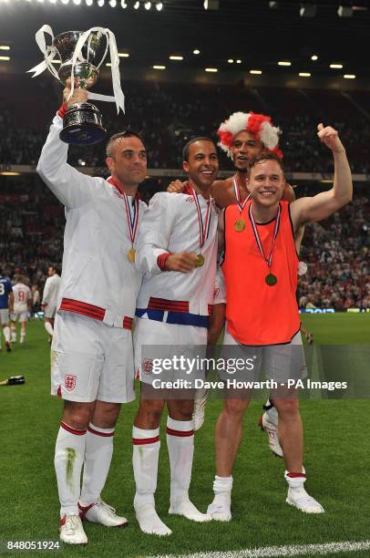 Robbie Williams, Marvin Humes Aston Merrygold and Olly Murs celebrate after England's victory in the match at Old Trafford for Soccer Aid.