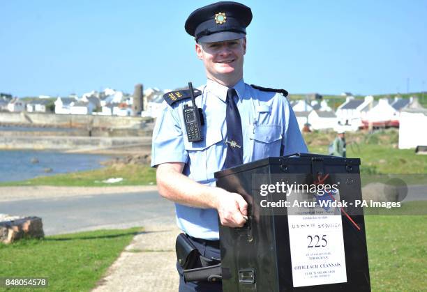 Garda Eugene Organ carrying a ballot box to the polling station for voting on the fiscal treaty referendum on Tory Island off the coast of Donegal,...