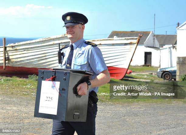 Garda Eugene Organ carrying a ballot box to the polling station for voting on the fiscal treaty referendum on Tory Island off the coast of Donegal,...