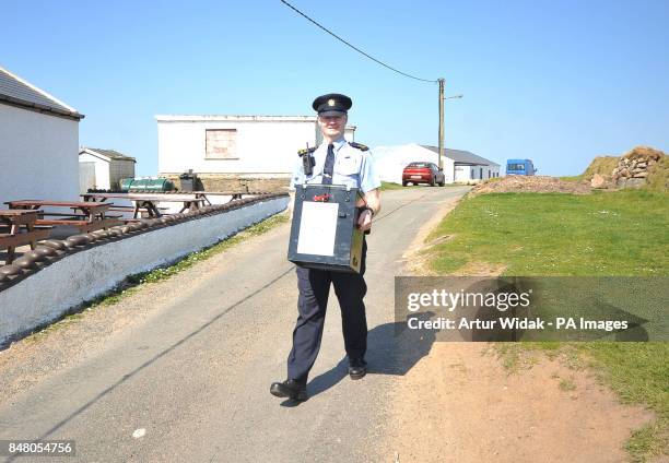 Garda Eugene Organ carrying a ballot box to the polling station for voting on the fiscal treaty referendum on Tory Island off the coast of Donegal,...