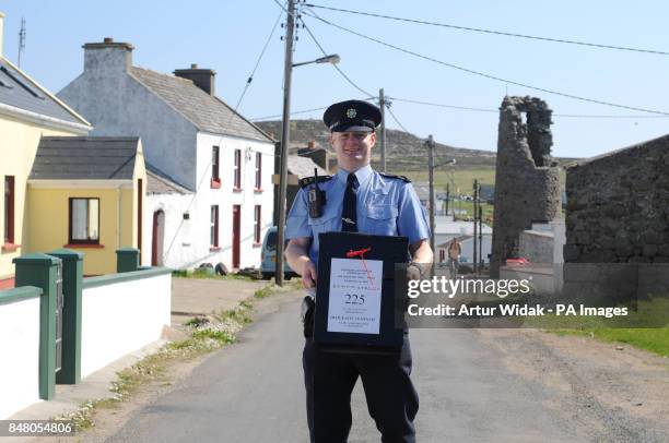 Garda Eugene Organ carrying a ballot box to the polling station for voting on the fiscal treaty referendum on Tory Island off the coast of Donegal,...