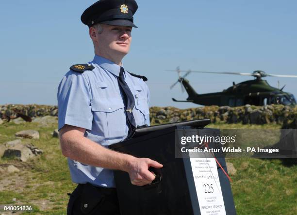 Garda Eugene Organ carrying a ballot box to the polling station for voting on the fiscal treaty referendum on Tory Island off the coast of Donegal,...