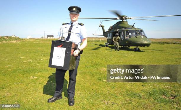 Garda Eugene Organ carrying a ballot box to the polling station for voting on the fiscal treaty referendum on Tory Island off the coast of Donegal,...