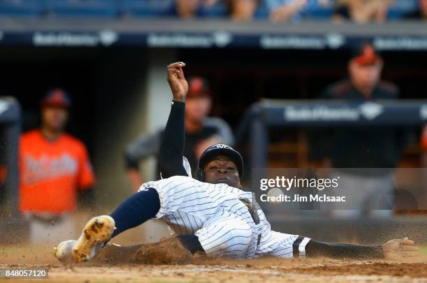 Didi Gregorius of the New York Yankees avoids the ball as he slides home for a run in the fifth inning against the Baltimore Orioles at Yankee...