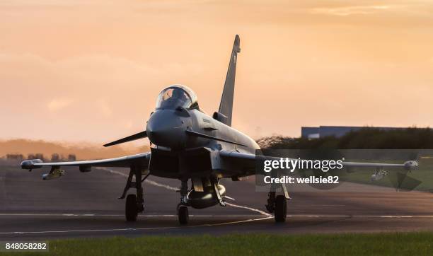 backlit typhoon taxis out for takeoff - raf harrier jet stock pictures, royalty-free photos & images