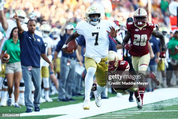 Brandon Wimbush of the Notre Dame Fighting Irish evades a tackle by Kevin Bletzer of the Boston College Eagles to score a touchdown during the second...