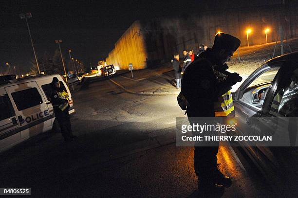 Police officers stand next a prison in Moulins, central France, on February 15, 2009 after two prisoners used explosives to blast their way out of...