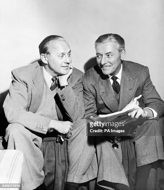Comedian Jack Benny, left, and British-born actor Ronald Coleman, conferring amiably over a script in Hollywood, USA.