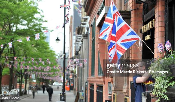 Dan Williams puts up a union flag at during preparations for a Jubilee street party on Canal Street in Manchester.