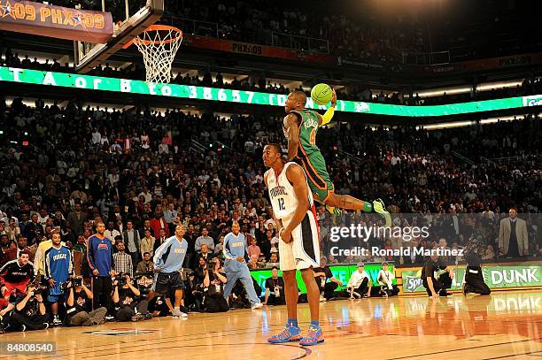 Nate Robinson of the New York Knicks leaps over Dwight Howard of the Orlando Magic in the finals of the Sprite Slam Dunk Contest on All-Star Saturday...