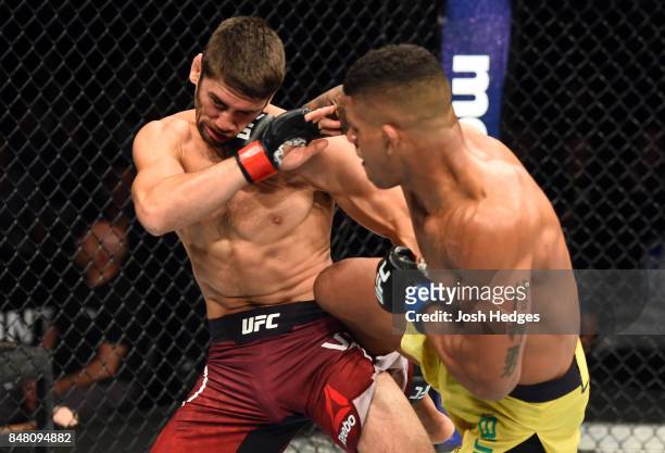 Gilbert Burns of Brasil punches Jason Saggo of Canada in their lightweight bout during the UFC Fight Night event inside the PPG Paints Arena on...
