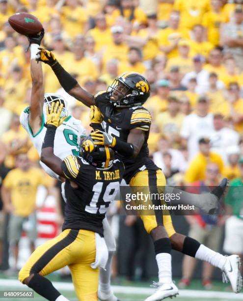 Defensive backs Josh Jackson and Miles Taylor of the Iowa Hawkeyes break up a pass intended for wide receiver Jalen Guyton of the North Texas Mean...