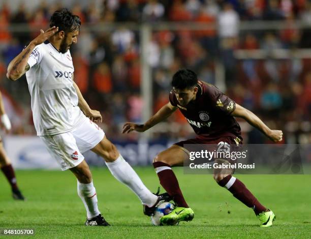Marcelino Moreno of Lanus fights for the ball with Jonas Gutierrez of Independiente during a match between Independiente and Lanus as part of the...