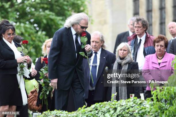 Bee Gee Barry Gibb lays a rose at the funeral of his brother Robin Gibb at St Mary's Church in Thame, Oxfordshire.