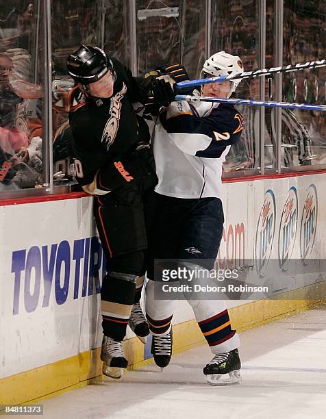 Garnet Exelby of the Atlanta Thrashers checks Corey Perry of the Anaheim Ducks into the boards during the game on February 15, 2009 at Honda Center...