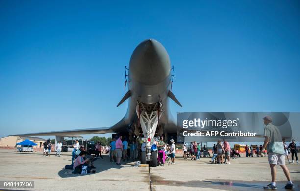 Man looks up at a B-1 Lancer bomber during the airshow at Joint Andrews Air Base in Maryland on September 16, 2017. / AFP PHOTO / Andrew...