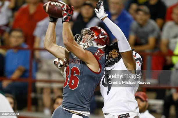 Luke Mayock of the Miami Ohio Redhawks catches a touchdown defended by Linden Stephens of the Cincinnati Bearcats during the first half at Yager...